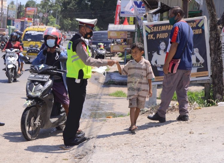 Dengan Humanis Anggota Ditlantas Polda NTT Bagikan Masker Kepada Anak Usia Dini