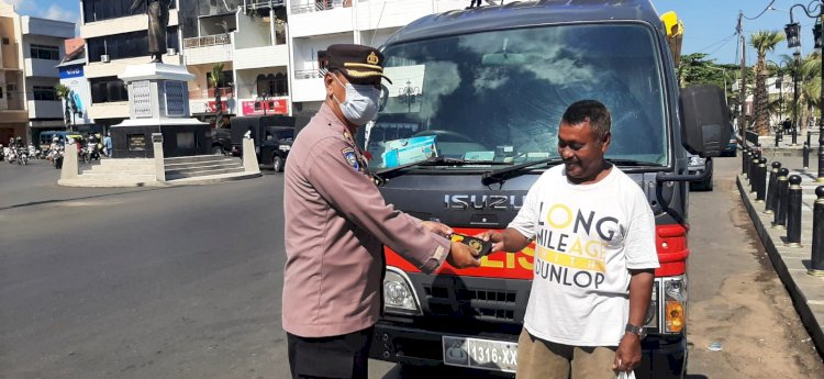 Ingatkan Prokes, Anggota Ditbinmas Polda NTT Bagikan Masker kepada Warga