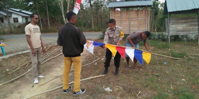 Bhabinkamtibmas Polres Belu himbau dan bantu masyarakat hiasi jalanan depan kantor desa