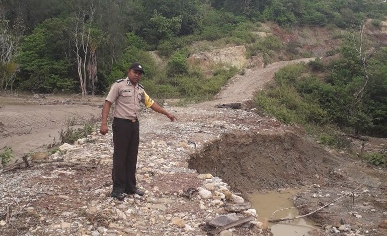 Jalan Sabuk Merah Rusak, Bhabinkamtibmas Sarabau Polres Belu Himbau Pengendara Waspadai Longsor Susulan