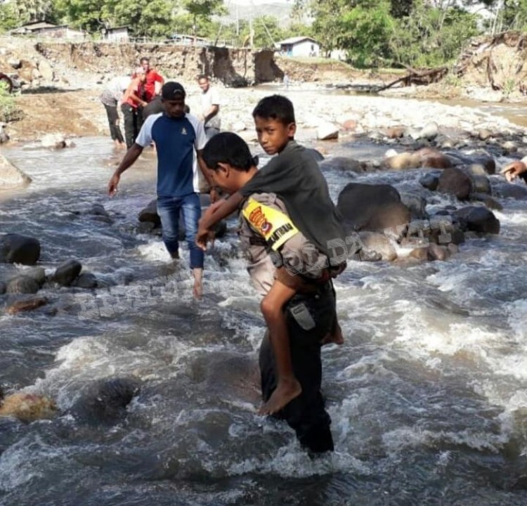 Bhabinkamtibmas Kolisia Bantu Wanita dan Anak Sebrangi Kali Akibat Putusnya Jembatan