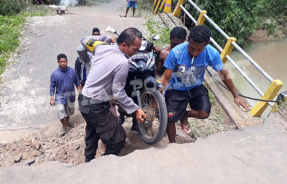 Aksi Heroik Brigpol Soalihin Membantu Mengangkat Sepeda Motor Warga yang Melintasi Jembatan Wailamung