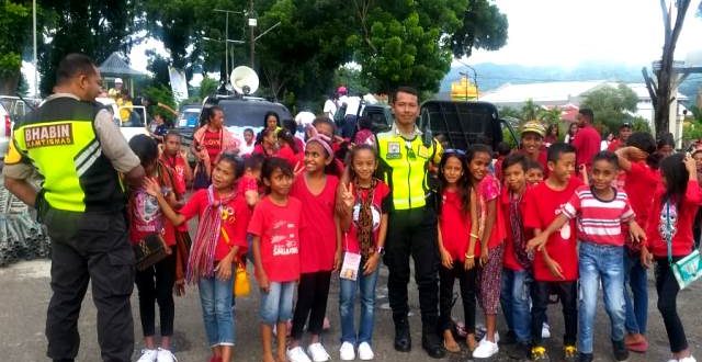 Berikan Rasa Aman dan Nyaman, Bhabinkamtibmas Bripka Thomas Raya Kawal Pawai Kontingen Pesparani